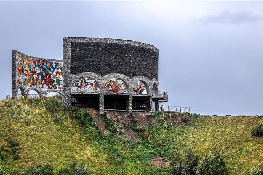 The curved stone and mosaic Russia-Georgia Friendship Monument above the Devil's Valley